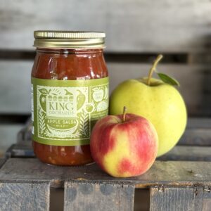 Apple Salsa Jar with a two apples on a crate